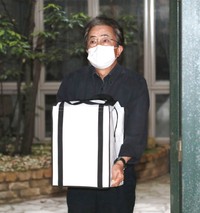 自宅に戻った岡江久美子さんの遺骨を大事そうに抱え、報道陣に対応する大和田獏=2020年