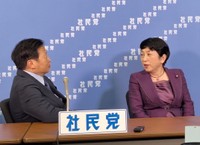 ８日夜の会見前、衆院選の開票状況を受けて語り合う社民党の福島瑞穂党首（右）とラサール石井副党首＝都内