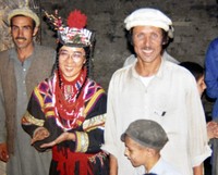 パキスタン北西部のカラーシャの谷で1993年夏、大勢の村人が見届けるなか、ヒツジを神に捧げる儀礼で結婚を祝った和田晶子さん（中央左）と、夫のジャマット・カーンさん（右）＝和田さん提供