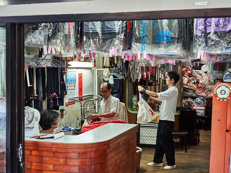 Reef Chang, right, who dreamed up the Instagram account idea for the laundry business of his grandparents Hsu Sho-er, left, and Chang Wan-ji, at the business in Taichung, Taiwan, July 23, 2020. The octogenarian owners of Wansho Laundry in central Taiwan have become Instagram stars for posing in garments left behind. (An Rong Xu/The New York Times)