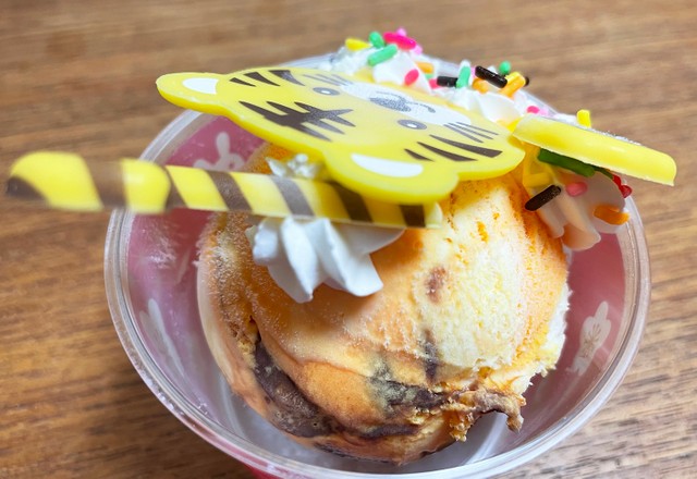 「ハッピードール とら」を後ろから見た図。好みのフレーバーの上に「とら」を模したかわいいチョコレートプレートやデコレーションが乗っており、味も見た目も楽しい仕上がりに！