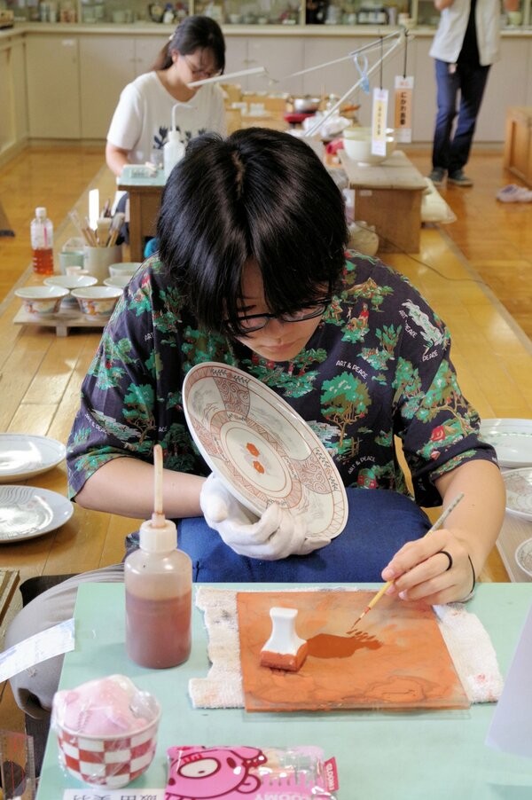 緻密な文様を皿に描く絵付デザイン科の訓練生