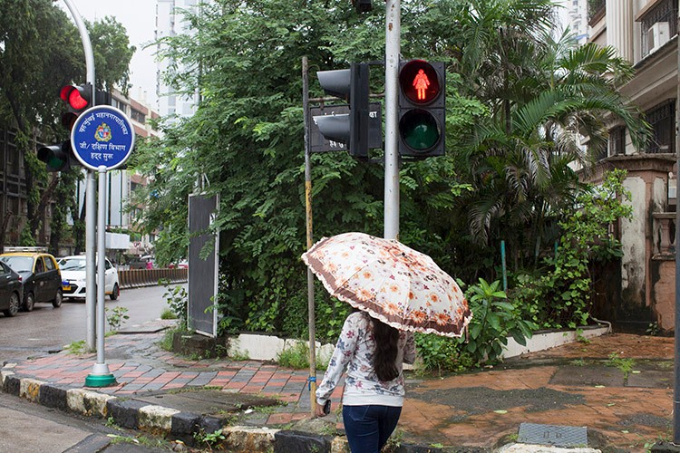 A pedestrian crossing light with one of the new female silhouettes in the Dadar neighborhood of Mumbai, Aug. 6, 2020. At many crossings, Indiaﾕs largest city replaced male stick figures with icons in triangular dresses. But critics say the move does little to address an entrenched gender divide. (Prarthna Singh/The New York Times)
