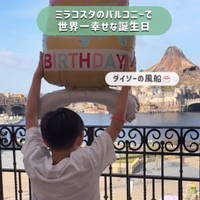 朝の光の中、風船を掲げる息子さん。まだ静かな広場の先に、キャストが姿を見せ始める／ゆっきーさん（@yuki.m.h）提供