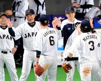 韓国戦に勝利し笑顔で坂本勇人（背番号６）らナインを出迎える大谷翔平（中央）と小久保裕紀監督（左から２人目）=2015年