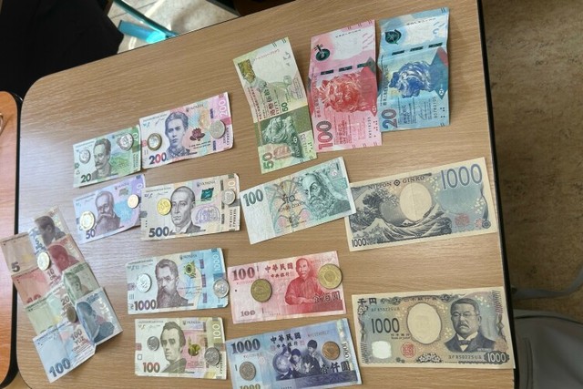 休み時間にクラスメイトと自国の通貨を紹介しあった＝小林杏樹撮影