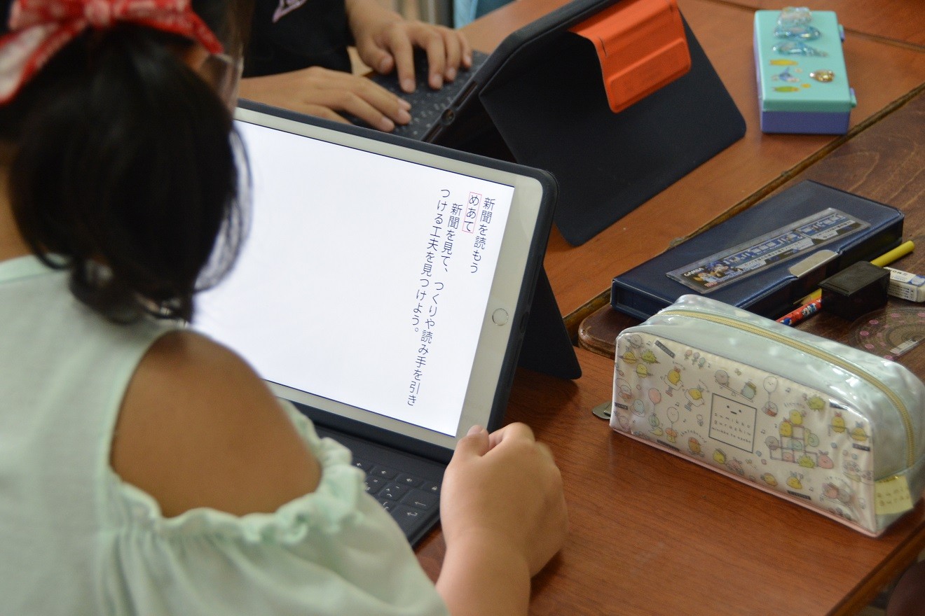 タブレットを使って板書を写す子どもたち