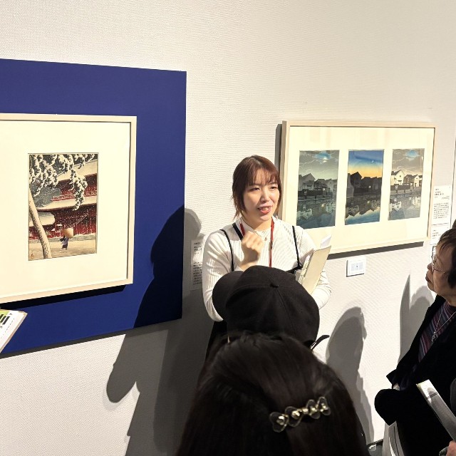 「ここに注目してください」。学芸員の一言に、来場者の視線が作品へと集まる＝神戸ファッション美術館