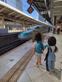 はやぶさの先頭部分が見える場所で見学する子どもたち。新幹線好きが伝わる装いでホームへ向かった／MOEさん（@hoppe.mochimochi）提供