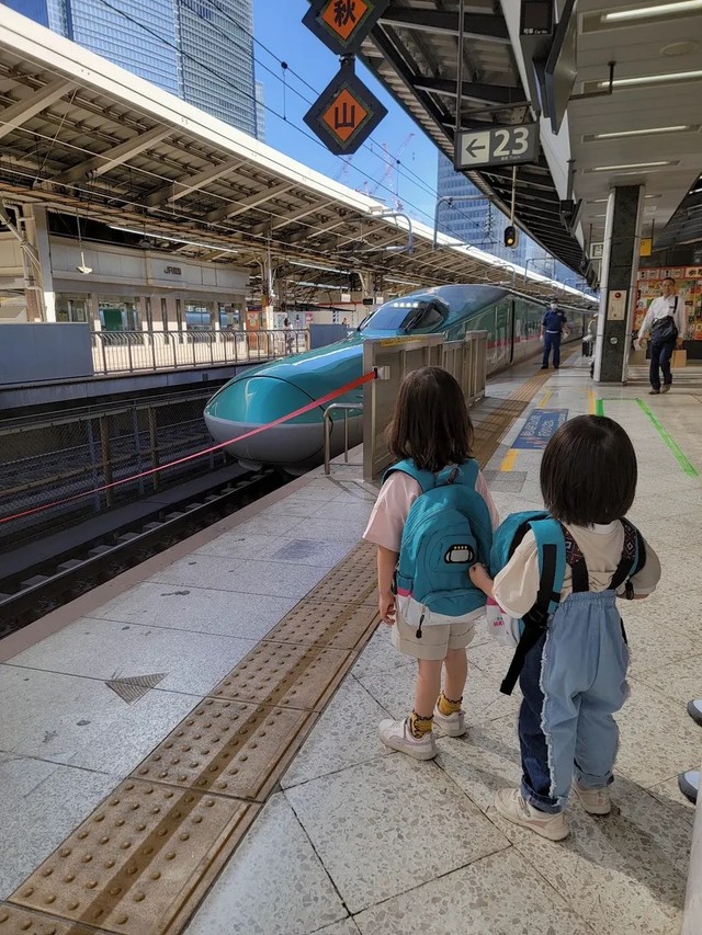 はやぶさの先頭部分が見える場所で見学する子どもたち。新幹線好きが伝わる装いでホームへ向かった／MOEさん（@hoppe.mochimochi）提供