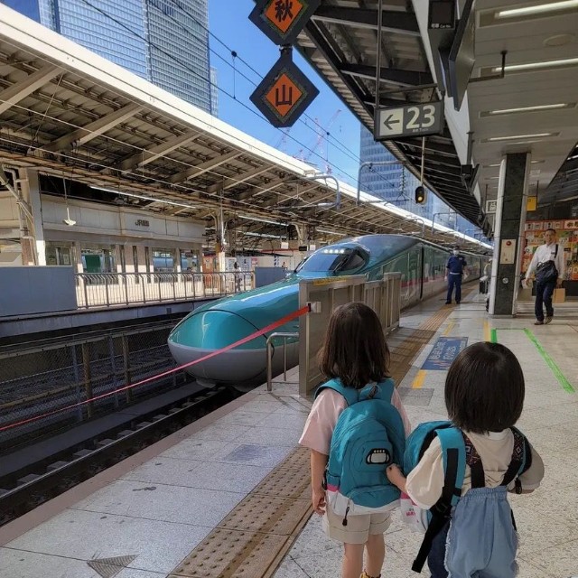 はやぶさの先頭部分が見える場所で見学する子どもたち。新幹線好きが伝わる装いでホームへ向かった／MOEさん（@hoppe.mochimochi）提供