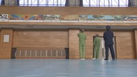 受刑者2人がパネルを見るため体育館を訪れた