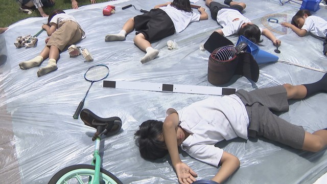 感光シートの上で思い思いのポーズで寝転がる男木島の小中学生