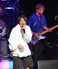 熱唱する近藤真彦。後方は野村義男＝2023年