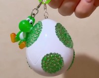 ウォンナさんが持っているヨッシーガチャ。タマゴにもヒートン（頭部がリング状になった金具）とカニカンを付け、デコってみたそう（ウォンナさん提供）