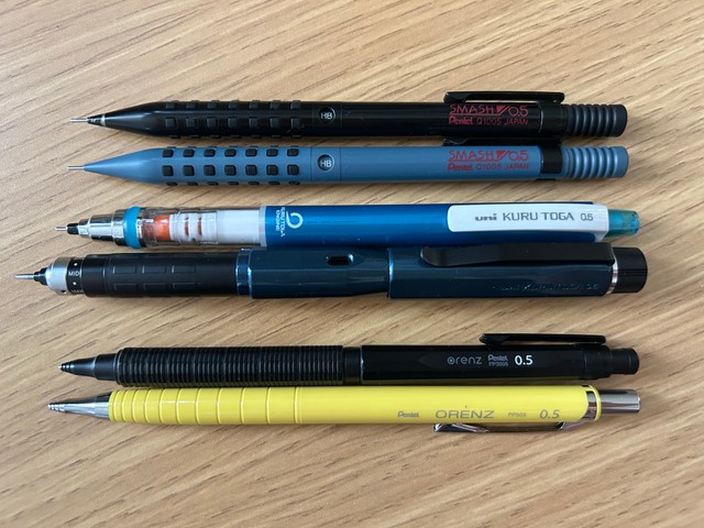 上からぺんてるの「SMASH」「SMASH Amazon.co.jp限定」、三菱鉛筆の「クルトガ」「クルトガ ダイブ」、ぺんてるの「オレンズネロ」「オレンズ」。いずれも芯が出る部分（ガイドパイプ）の長さや、芯出しの機構、グリップに工夫が施されている（私物筆者撮影）