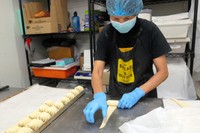 クロワッサンの形にパン生地を巻くマドゥさん=2021年2月3日、シドニー、小暮哲夫撮影
