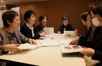 ノートを見て思い出話で盛り上がる村上さん（左から２人目）や松井さん（左）たち＝京都市下京区のホテル