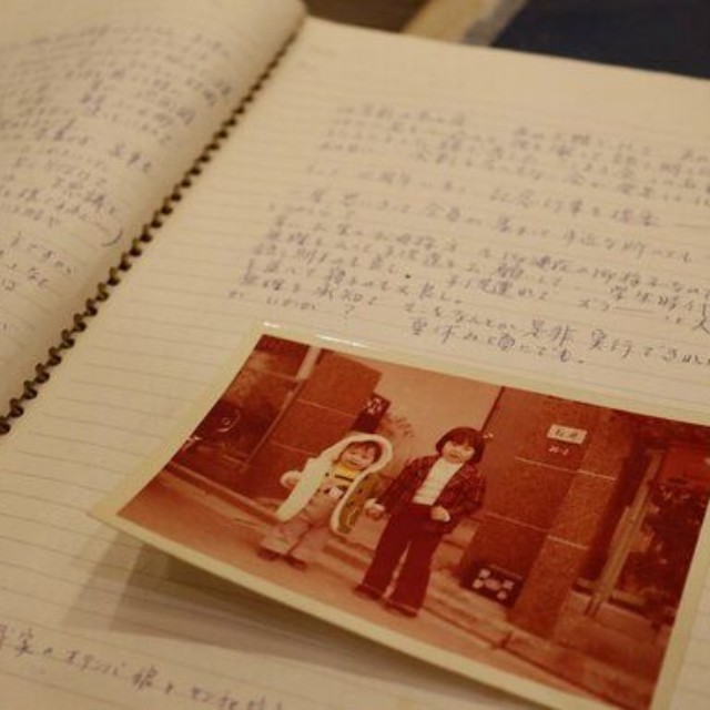 ノートの交換を始めたころのページ。子どもの写真が貼られ、育児の様子がつづられている