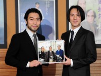 「大岡越前」で共演した父・加藤剛さんとの思い出の写真を手にする次男・加藤頼（左）と長男・夏原諒＝2018年