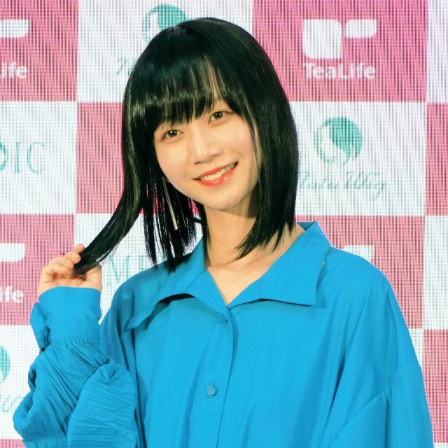 セミロングの黒髪ウイッグで笑みを浮かべる三戸なつめ＝2020年