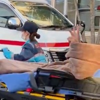 担架で運ばれている「傷病者」（※モデルは志摩市消防本部の職員さん）もダブルピース……こんな行為が横行しているという（動画からキャプチャー／提供：志摩市消防本部【公式】）