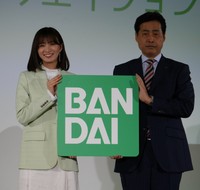 「未来・クリエイション」のキャンペーンボードを掲げる岡崎紗絵（左）、バンダイの竹中一博社長＝東京・台東区