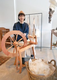 糸を紡ぐ久米さんは「羊の種類によって、繊維の色、太さ、弾力が異なる。それが面白い」と話す（彦根市大藪町）