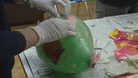 ゴム風船を膨らませ、和紙を貼り付けていく