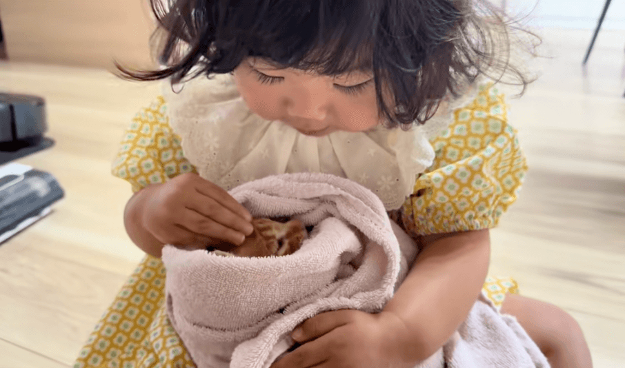 小さなみぞれくんを大切そうになでる娘さん（提供：いさまめfamilyさん）