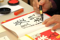 筆ペンで〝優待生活〟と書き、はんこを押していきます。