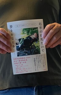 息子の自伝的書籍を持つ、ウッディさんの父