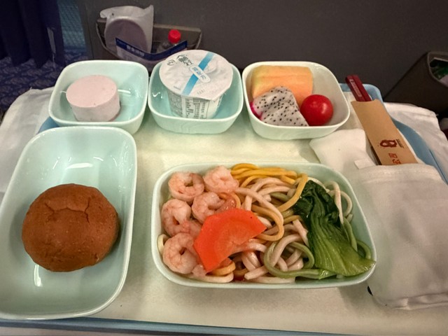 済南から重慶へ向かう便のビジネスクラスで出された機内食。こちらも麺とパンが並ぶ／どこにでも行くドスコイ（@nihongode_dozo）さん提供