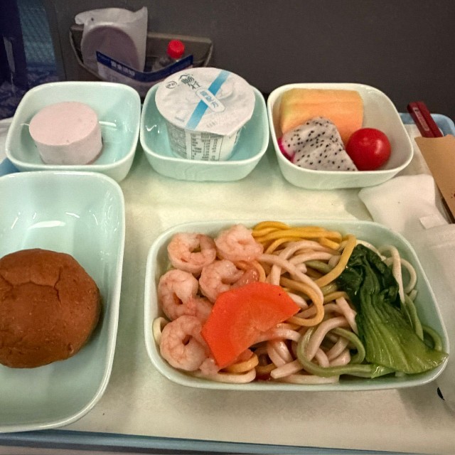 済南から重慶へ向かう便のビジネスクラスで出された機内食。こちらも麺とパンが並ぶ／どこにでも行くドスコイ（@nihongode_dozo）さん提供