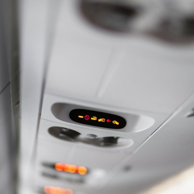 シートベルト着用サインが点灯する機内の様子。不安定な気流が続き、立ち上がれない状況だった　※この画像はイメージです（Atsuyuki/stock.adobe.com）