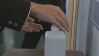 入り口で手を消毒する受験生