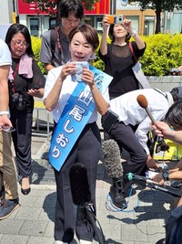 炎天下、参院選公示日の第一声を終え、報道陣に囲まれながら汗を拭う山尾志桜里氏＝ＪＲ吉祥寺駅前