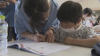 香川大学の学生が小学生と一緒に宿題に取り組む