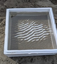 発泡スチロールの箱の中に浮かび上がった砂の縞模様。水の揺れが生み出した自然のアート／三谷 純さん（@jmitani）提供