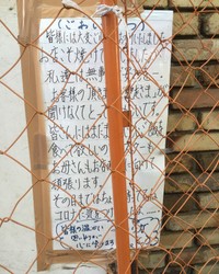 休業中の「薔薇亭」店頭に貼られたママさんのメッセージ。道行く人が立ち入り禁止のフェンス越しにその思いを読み取った=東京・高円寺