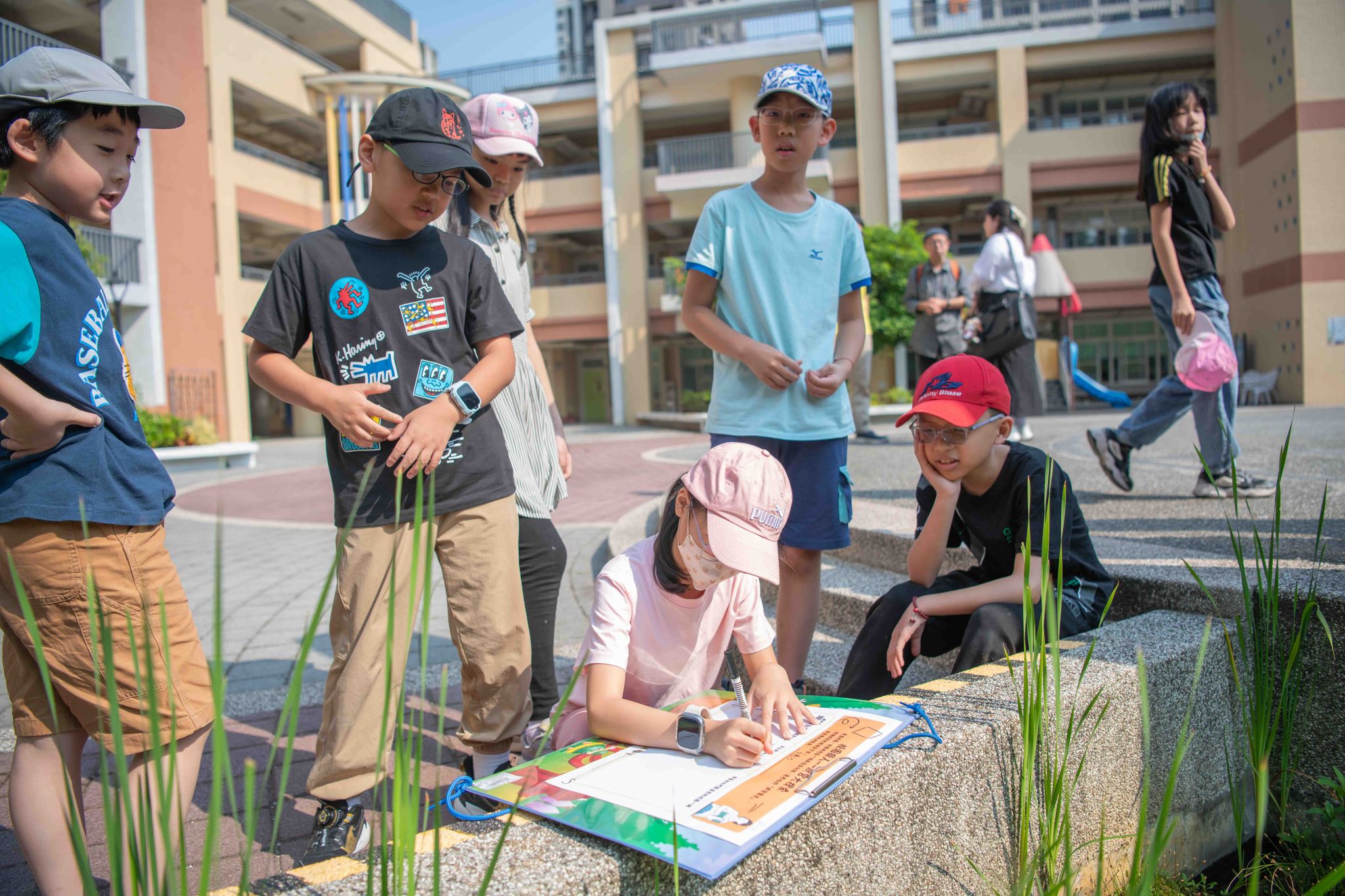 屋外で受ける国語の授業中、五感で得た情報を紙に書き留める台湾の児童ら