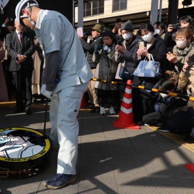 多くのファンが見守る中、行われた成瀬あかりを描いたマンホールのふたの設置作業（大津市馬場２丁目）