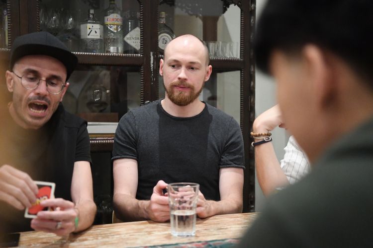 コリビング施設の共有ダイニングに集まった仲間と、カードゲームで遊ぶフランス出身の起業家ティボーさん