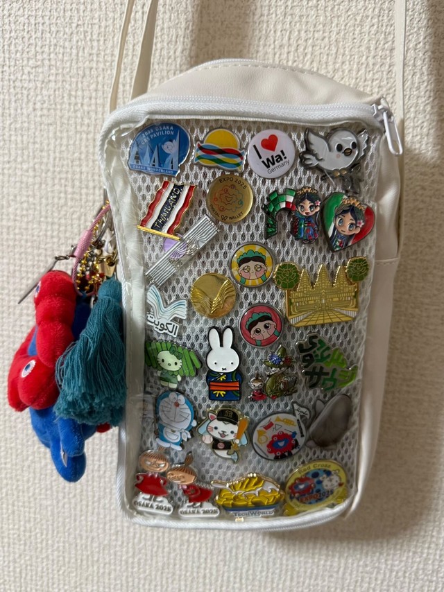 Ikueさんが楽しんでいる万博ピンバッチ集め。クリアポケット付きショルダーに飾って“見せバッグ”に。紛失防止にも◎（IkueさんThreadsより）