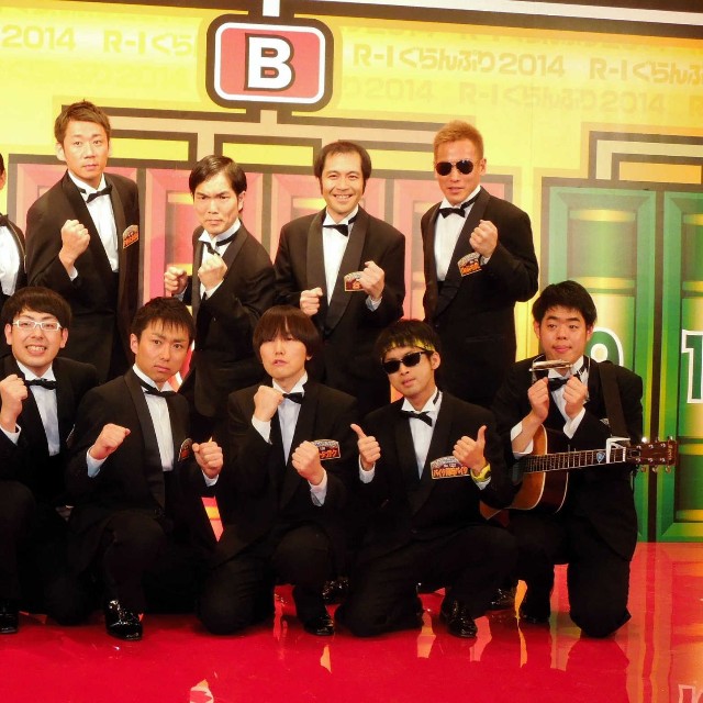 Ｒ―１決勝に進出した（前列左から）レイザーラモンＲＧ、ヒューマン中村、小森園ひろし、ミヤシタガク、バイク川崎バイク、馬と魚、（後列左から）ＴＡＩＧＡ、スギちゃん、やまもとまさみ、中山女子短期大学、おぐ、じゅんいちダビッドソン＝2014年