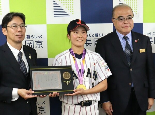 アジアカップで優勝し、長岡京市役所を表敬訪問した富田さん（中央）。市から「スポーツ賞優秀選手賞」の表彰盾を受け取った（市役所）