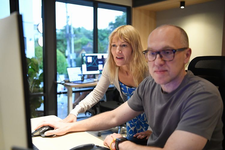 コワーキングスペースで、夫のパオロさん（手前）とパソコン画面をのぞき込み、イメージをつくりあげるマルタさん