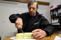 スティルトンチーズを切るロバート・ゴスリングさん=2021年3月3日、英中部ダービーシャー、和気真也撮影
