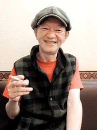 タバコをくゆらせインタビューに応える木村充揮＝2019年