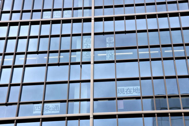 格子状の窓枠で京都の街並みを再現している「日本生命四条ビル」で、「四条烏丸」付近を再現した部分。工事中の室内に通り名の張り紙を掲示していた（京都市下京区四条通東洞院東入ル）